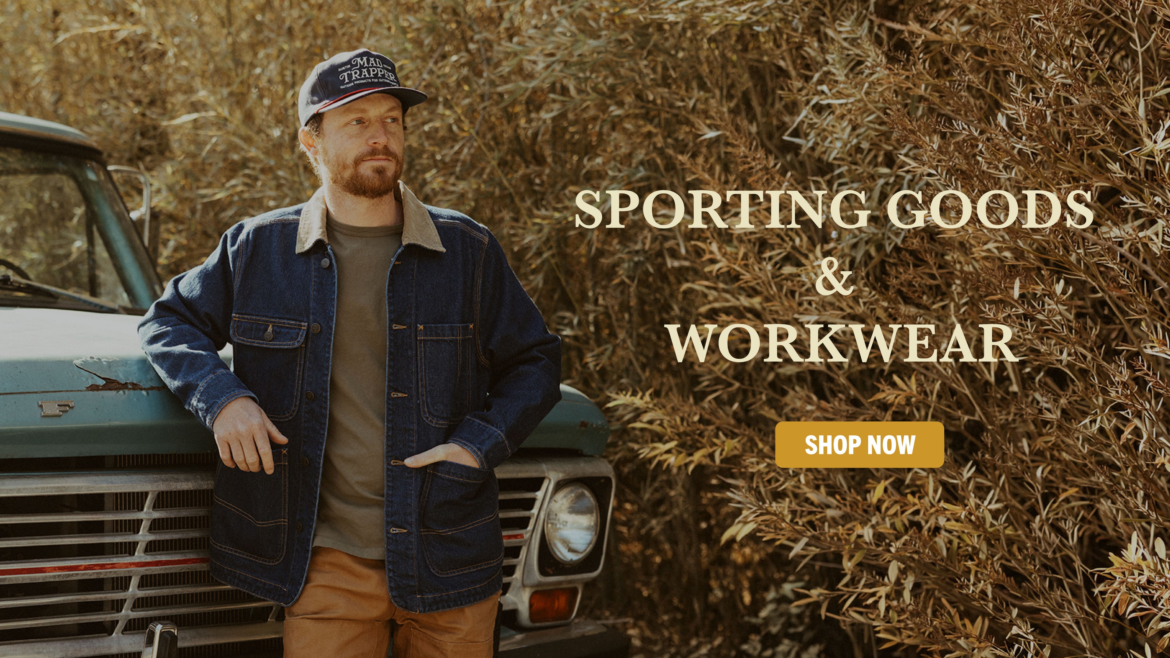 Sporting Goods & Workwear Banner Image of man wearing Mad Trapper Denim Field Coat in front of old pickup truck. 