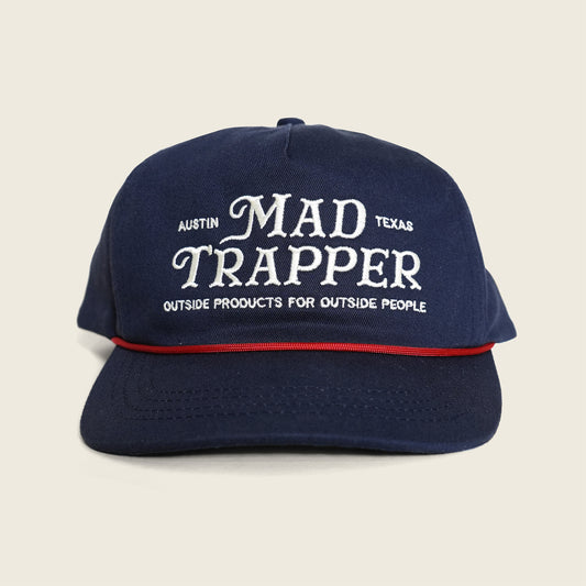 Navy blue cap with 'Mad Trapper' text on a beige background
